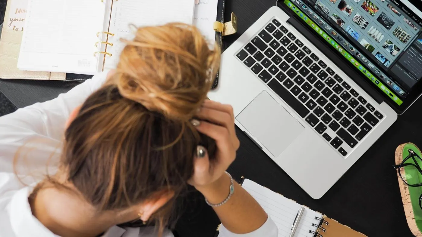 Woman with head in hands while working