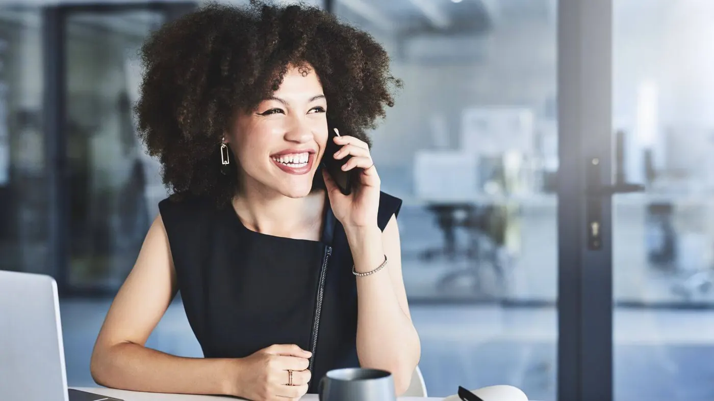 Woman working and smiling while talking on the phone