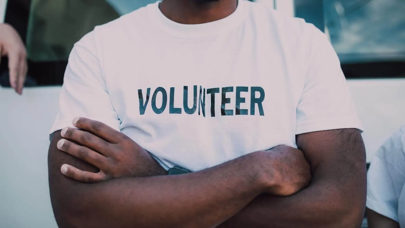 man with shirt that says "volunteer"