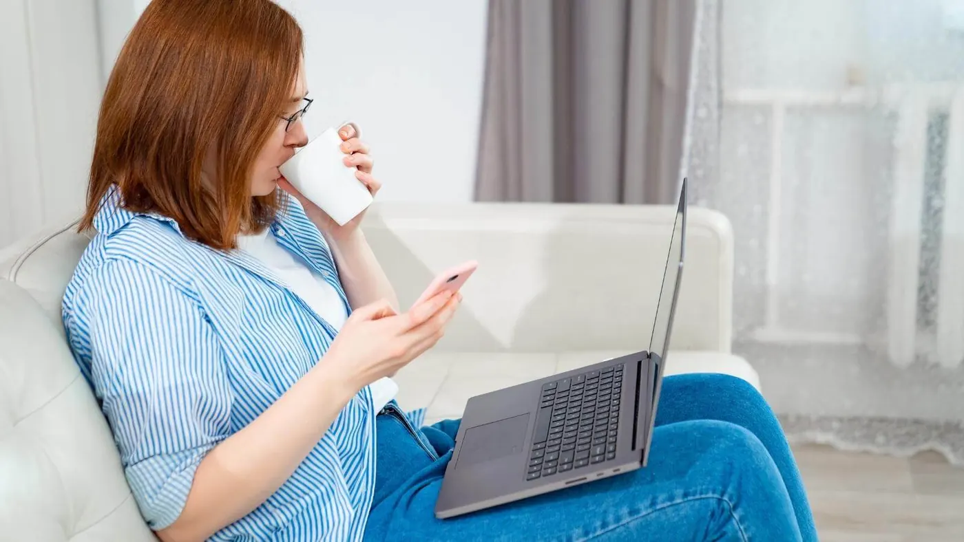 Woman drinking coffee and reading email.