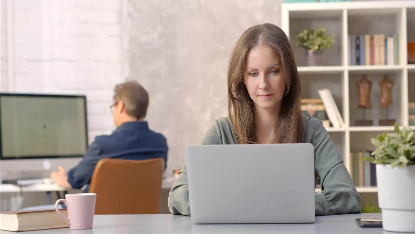 Woman working in an office looking at laptop comptuer